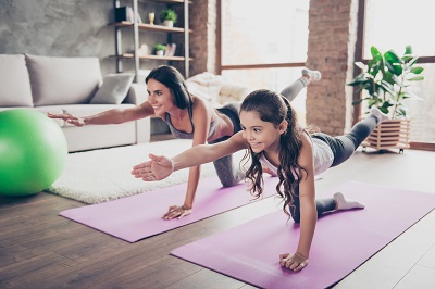 A mom and daughter do yoga together