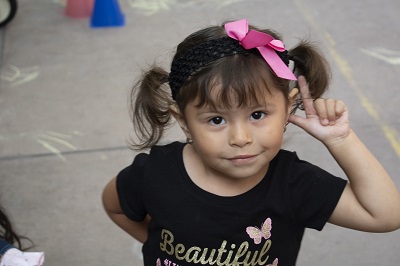 Smiling young girl wearing pink ribbon in hair