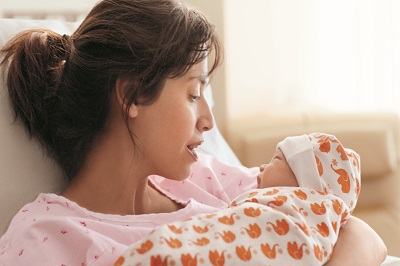 A mom cuddles her newborn baby