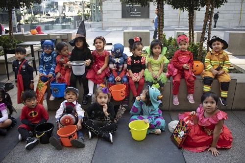 A group of Hope Street Margolis Family Center kids pose together for a photo in their Halloween costumes